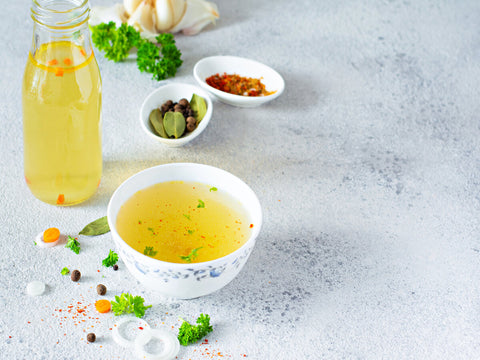 homemade chicken bone broth bouillon with vegetables and spices